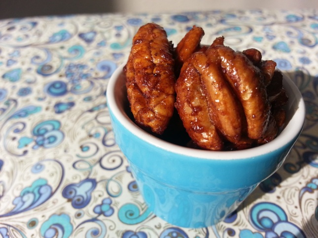Maple glazed pecans in a blue dish